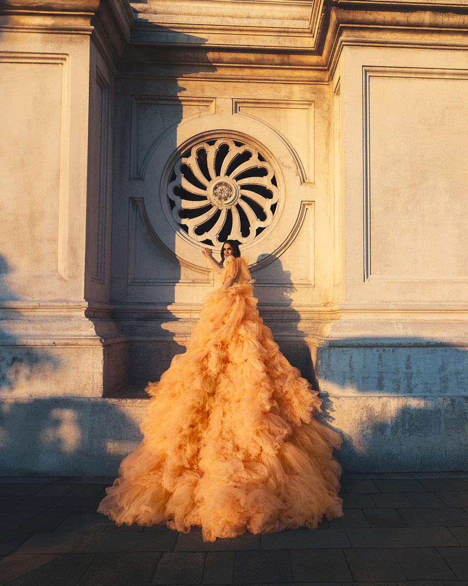 foto de mujer con vestido de fiesta recargada en la pared con contraste de luz y sombras. Diego De Rando, fotografo bodas.