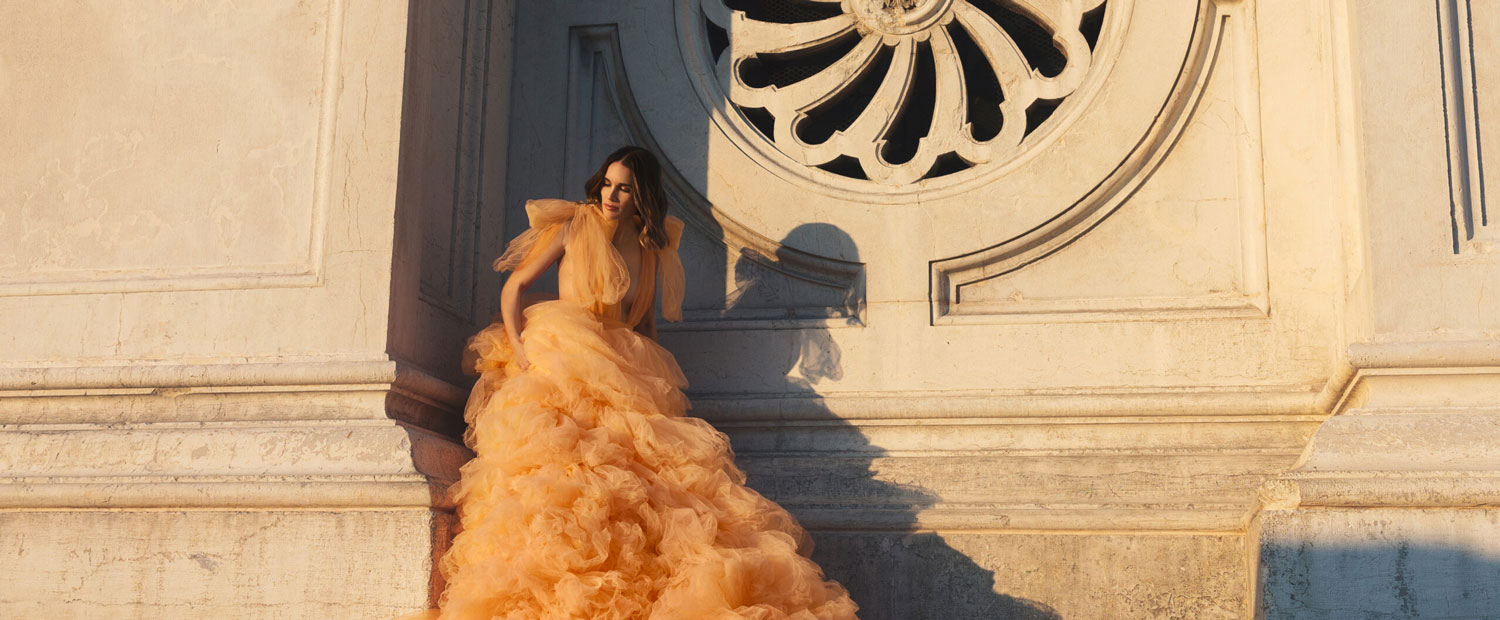 foto de mujer con vestido de fiesta recargada en la pared con contraste de luz y sombras. Diego De Rando, fotografo bodas.